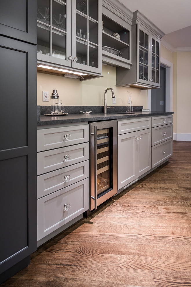 Eat-in kitchen - large transitional single-wall dark wood floor eat-in kitchen idea in Boston with an undermount sink, flat-panel cabinets, gray cabinets, granite countertops, white backsplash, ceramic backsplash, stainless steel appliances and an island