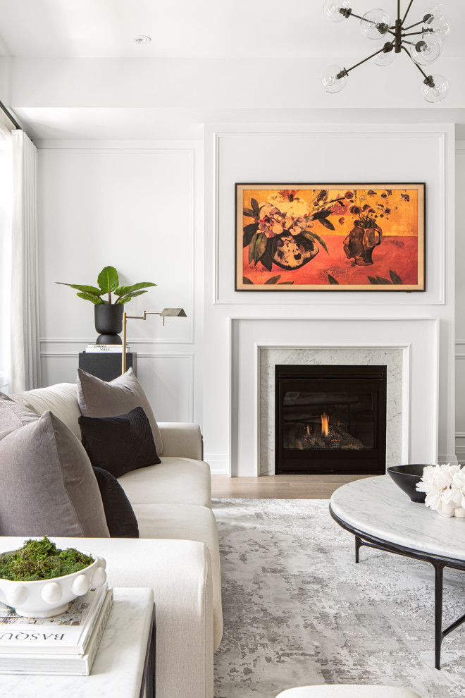 Photo of a large contemporary open concept living room in Toronto with white walls, light hardwood floors, a standard fireplace, a wood fireplace surround, a wall-mounted tv, white floor and decorative wall panelling.