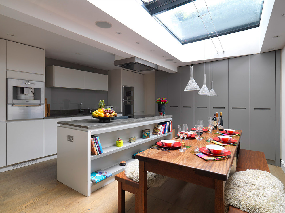 Design ideas for a small contemporary kitchen/dining combo in London with medium hardwood floors.