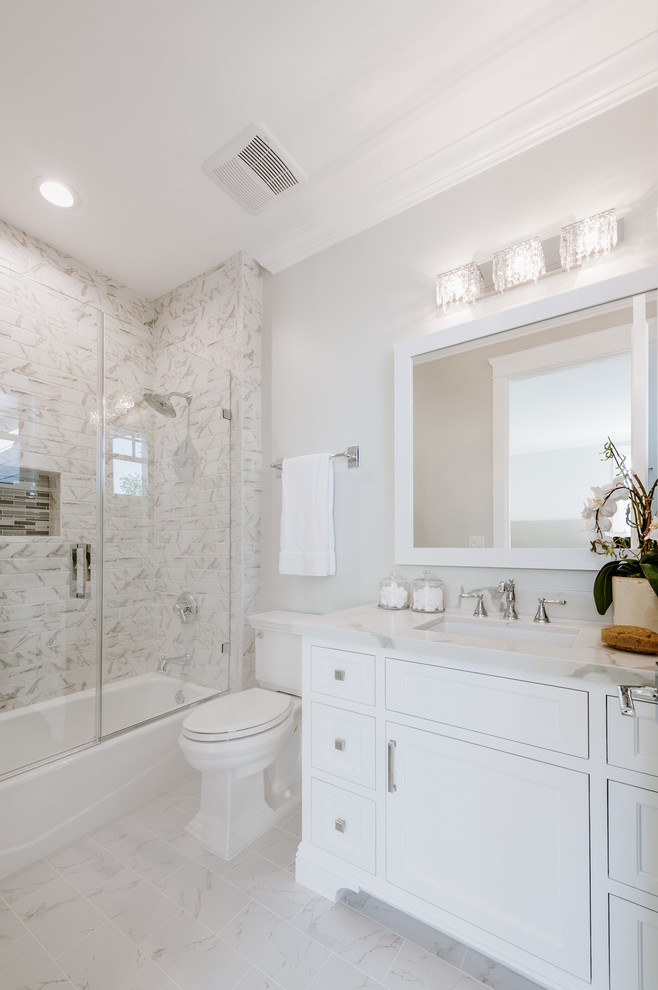 Small transitional bathroom in Los Angeles with white cabinets, an alcove tub, a shower/bathtub combo, a two-piece toilet, beige walls, an undermount sink, quartzite benchtops, a hinged shower door and recessed-panel cabinets.