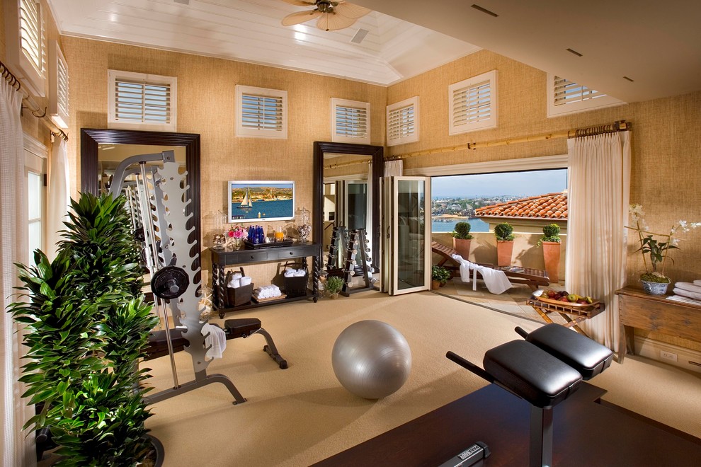 This is an example of a mid-sized tropical multipurpose gym in Orange County with beige walls, carpet and beige floor.