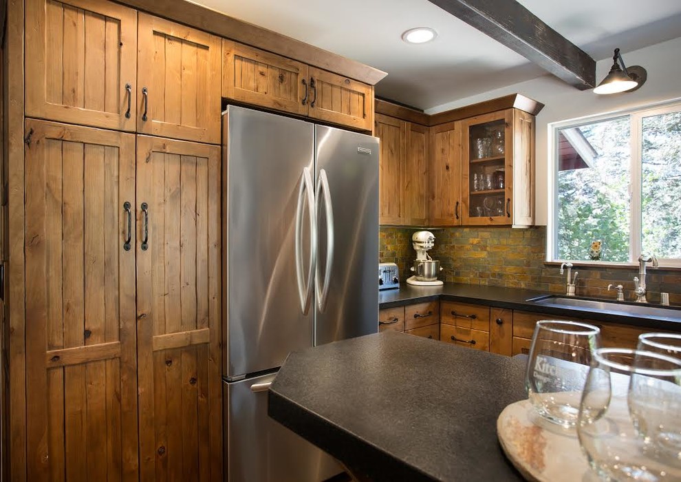 Example of a mid-sized mountain style u-shaped dark wood floor open concept kitchen design in San Luis Obispo with an undermount sink, flat-panel cabinets, distressed cabinets, granite countertops, multicolored backsplash, stone tile backsplash, stainless steel appliances and an island