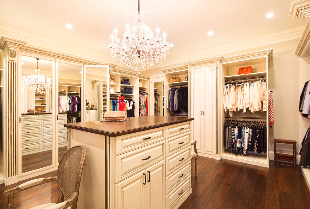 Large traditional gender-neutral dressing room in Atlanta with raised-panel cabinets, beige cabinets, dark hardwood floors and brown floor.