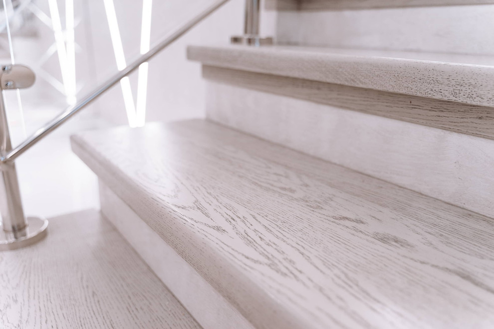 Diseño de escalera en U actual grande con escalones de madera, contrahuellas de hormigón, barandilla de madera y ladrillo