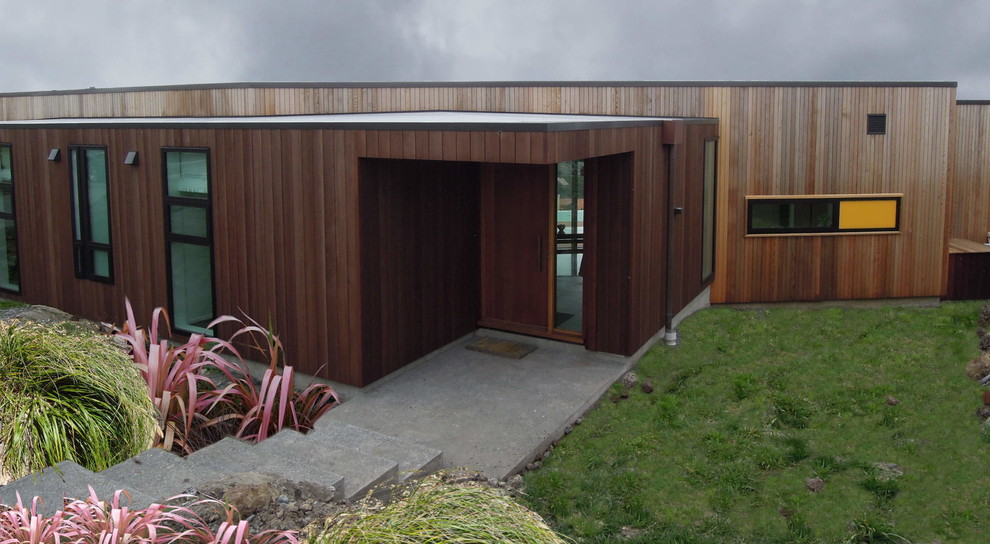 Photo of a mid-sized contemporary split-level exterior in Christchurch with wood siding.