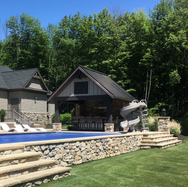 This is an example of an industrial backyard pool in Cleveland with a pool house.
