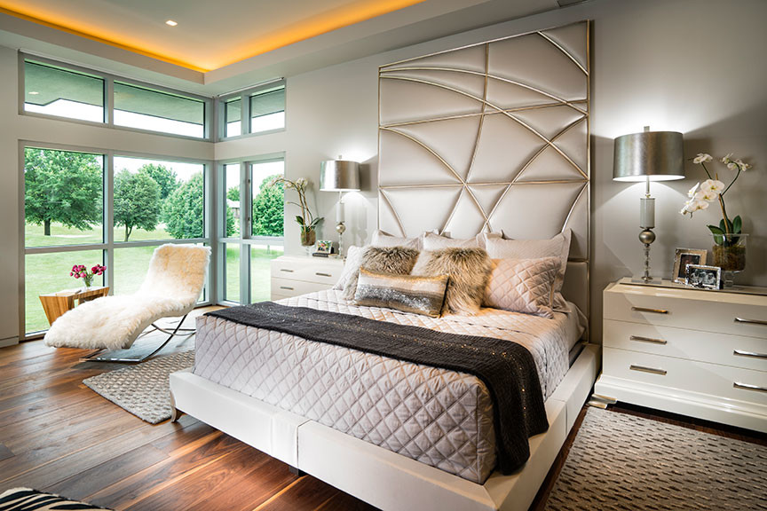 Inspiration for an expansive contemporary master bedroom in Other with white walls, medium hardwood floors, a two-sided fireplace, a stone fireplace surround and brown floor.