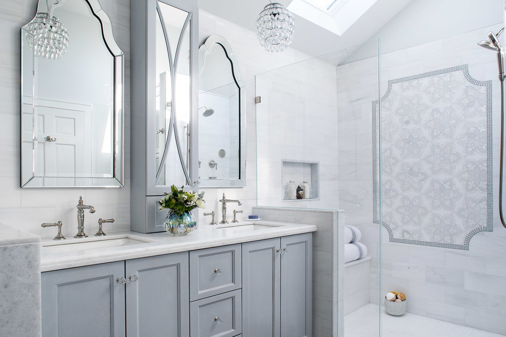 Design ideas for a mid-sized traditional master bathroom in New York with a corner shower, a one-piece toilet, white tile, marble, porcelain floors, quartzite benchtops, a hinged shower door, recessed-panel cabinets, grey cabinets, white walls, an undermount sink, grey floor and white benchtops.