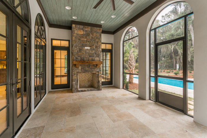 Inspiration for a large mediterranean stone screened-in back porch remodel in Jacksonville with a roof extension