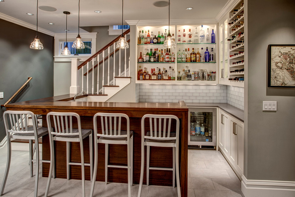 This is an example of a traditional l-shaped wet bar in Chicago with open cabinets, white cabinets, glass benchtops, white splashback and subway tile splashback.