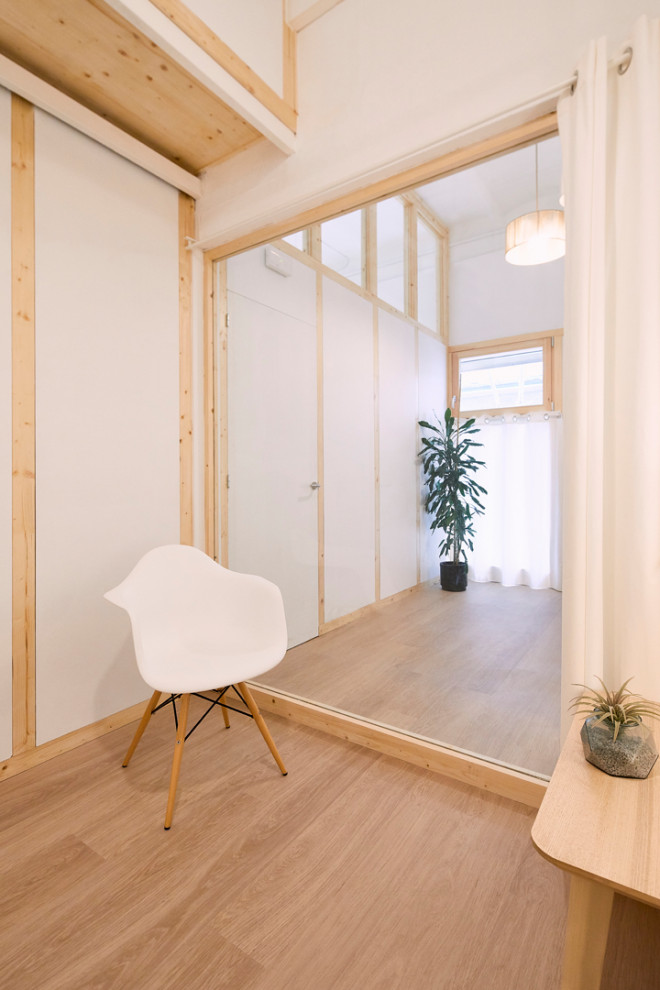 Inspiration for a small scandinavian enclosed family room in Other with white walls, light hardwood floors, beige floor, vaulted and wood walls.
