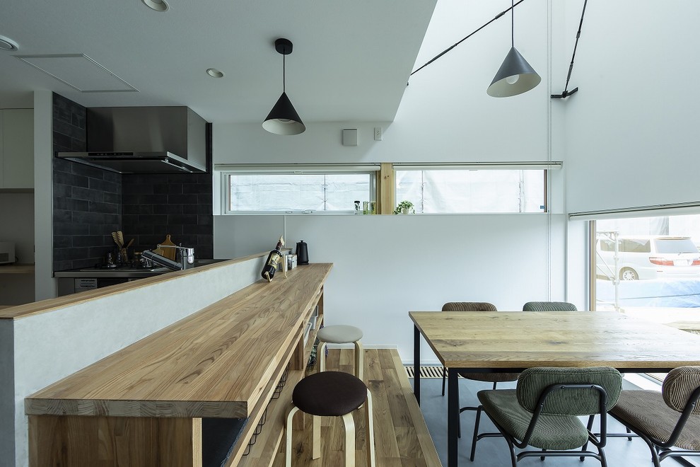 Inspiration for an industrial open plan dining in Other with white walls, concrete floors and grey floor.