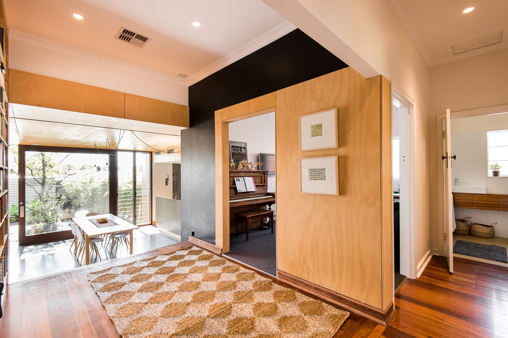Design ideas for a mid-sized transitional hallway in Perth with black walls and medium hardwood floors.