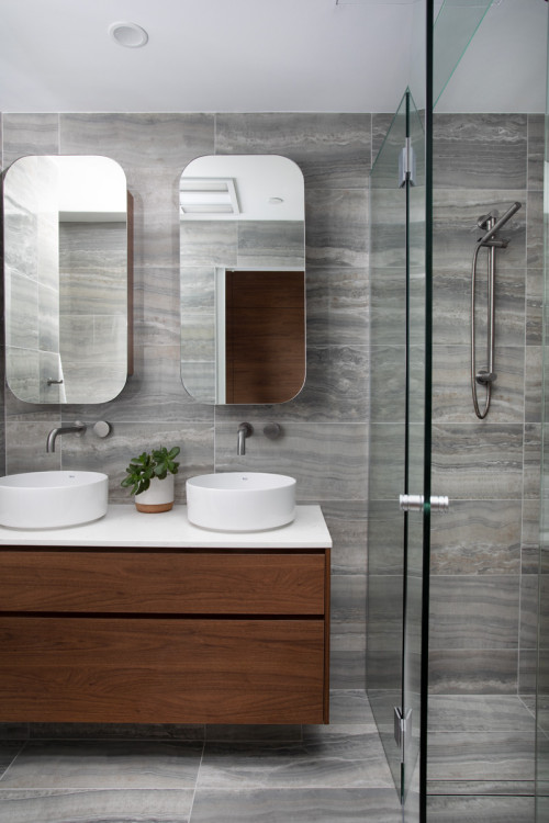 Wall-Mounted Sophistication: Oval Mirrors and White Countertop for Wood Bathroom Vanity