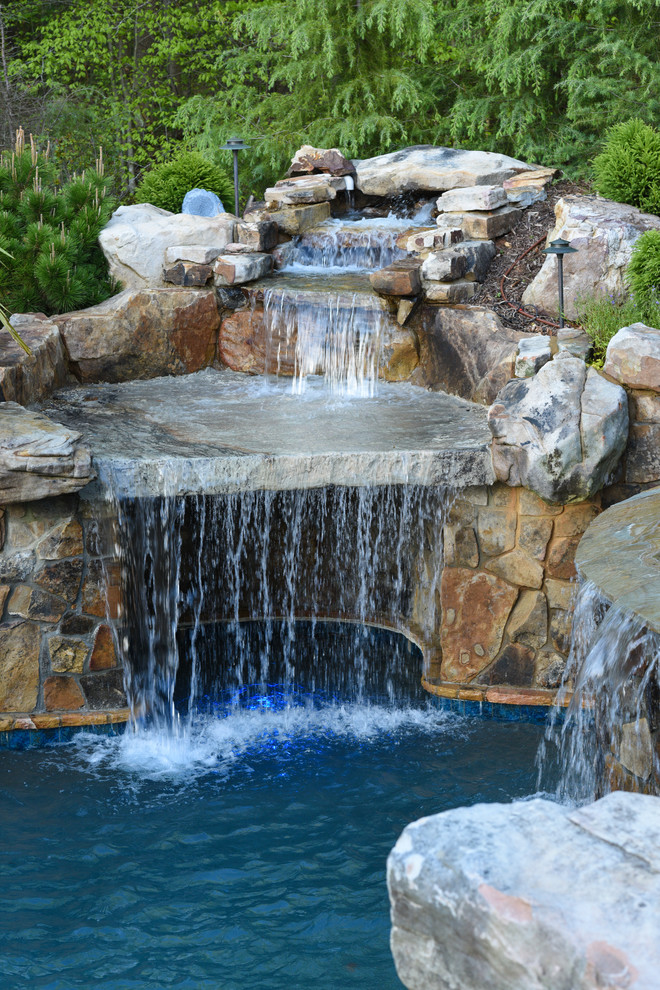 Photo of an expansive tropical backyard natural pool in Atlanta.