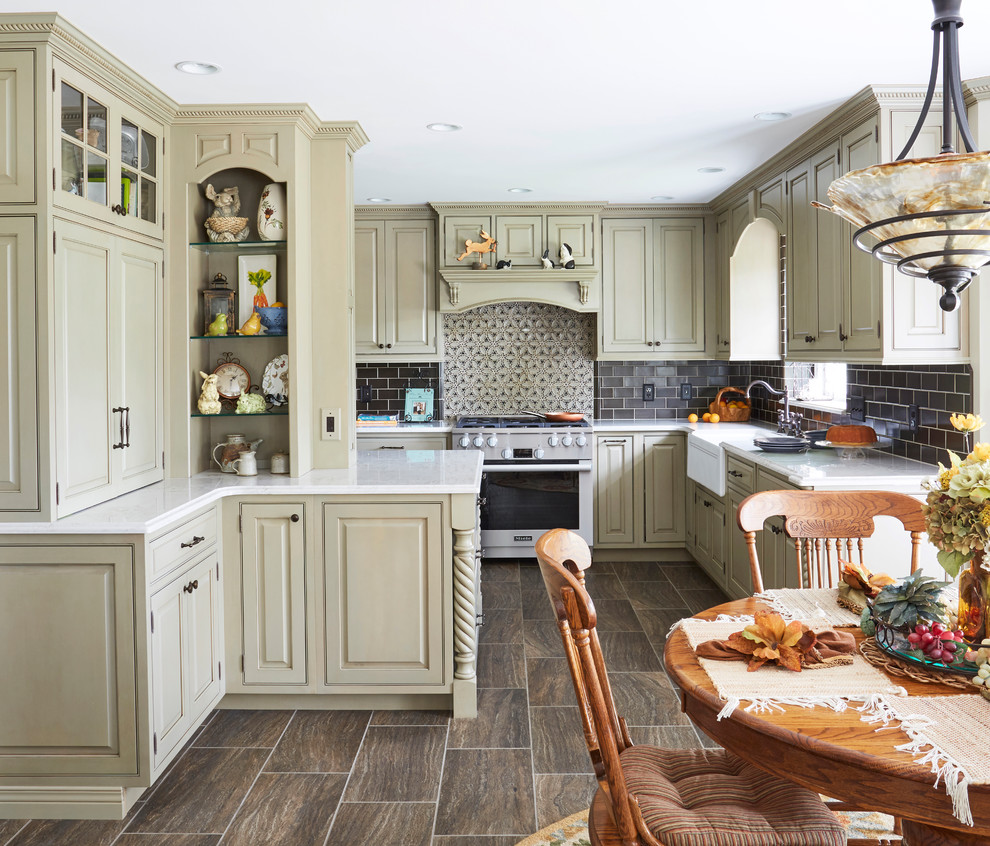 Example of a large classic u-shaped porcelain tile and brown floor eat-in kitchen design in Other with a farmhouse sink, quartz countertops, stainless steel appliances, raised-panel cabinets, gray backsplash, beige cabinets, porcelain backsplash, no island and white countertops