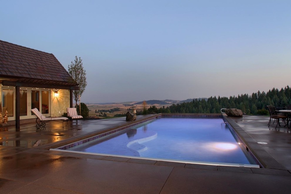 Design ideas for a large mediterranean backyard rectangular pool in Seattle with concrete slab.