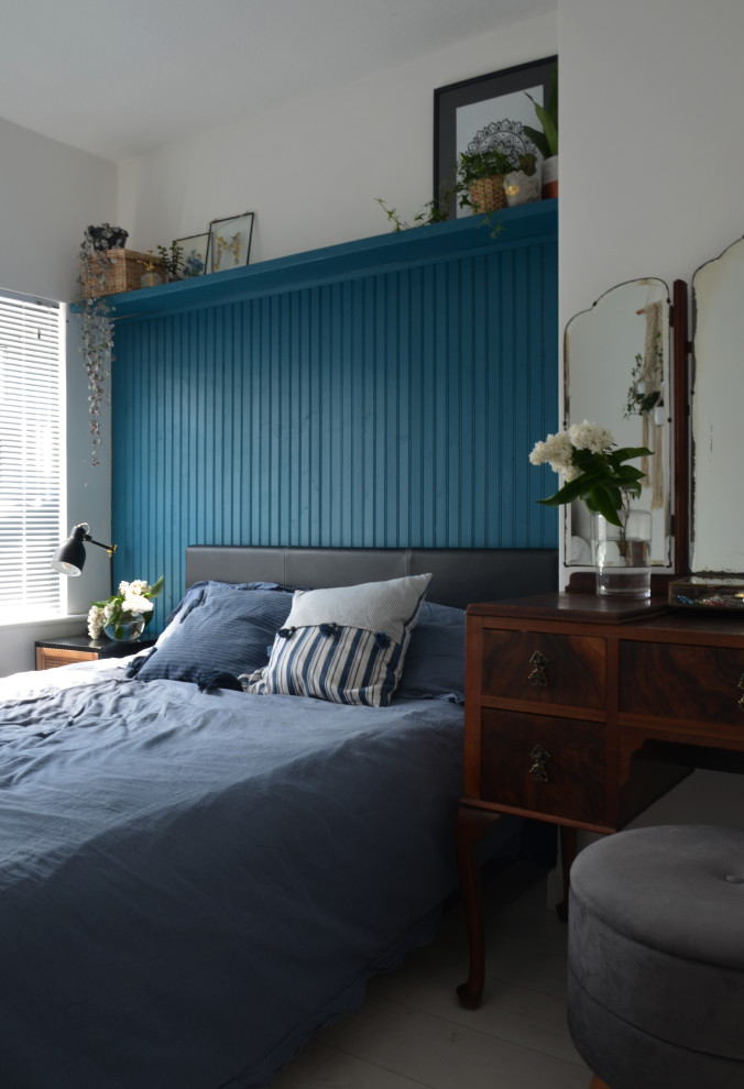 Cette image montre une petite chambre parentale bohème avec un mur bleu, sol en stratifié, aucune cheminée, un sol blanc et du lambris.