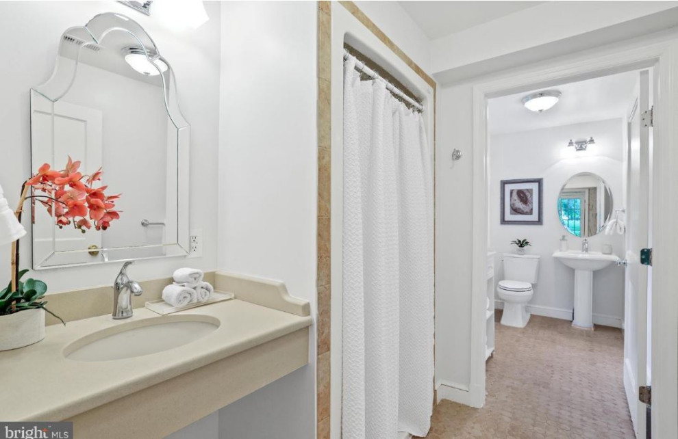 Esempio di una stanza da bagno chic con pavimento con piastrelle in ceramica, lavabo sospeso, top beige e un lavabo