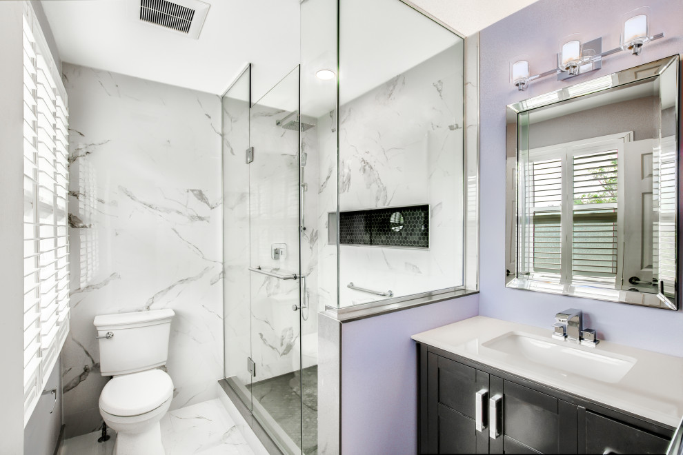 This is an example of a mid-sized contemporary master bathroom in Toronto with blue cabinets, an open shower, a two-piece toilet, yellow tile, porcelain tile, purple walls, porcelain floors, an undermount sink, engineered quartz benchtops, a hinged shower door, white benchtops, a niche, a single vanity and a freestanding vanity.