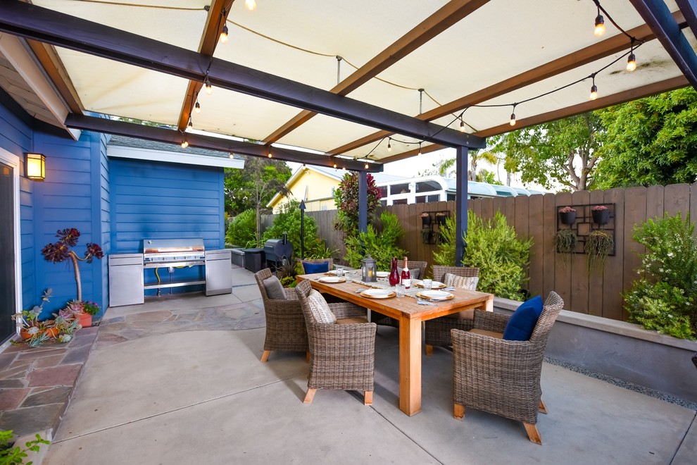 Photo of a mid-sized arts and crafts backyard patio in San Diego with concrete slab, a pergola and an outdoor kitchen.