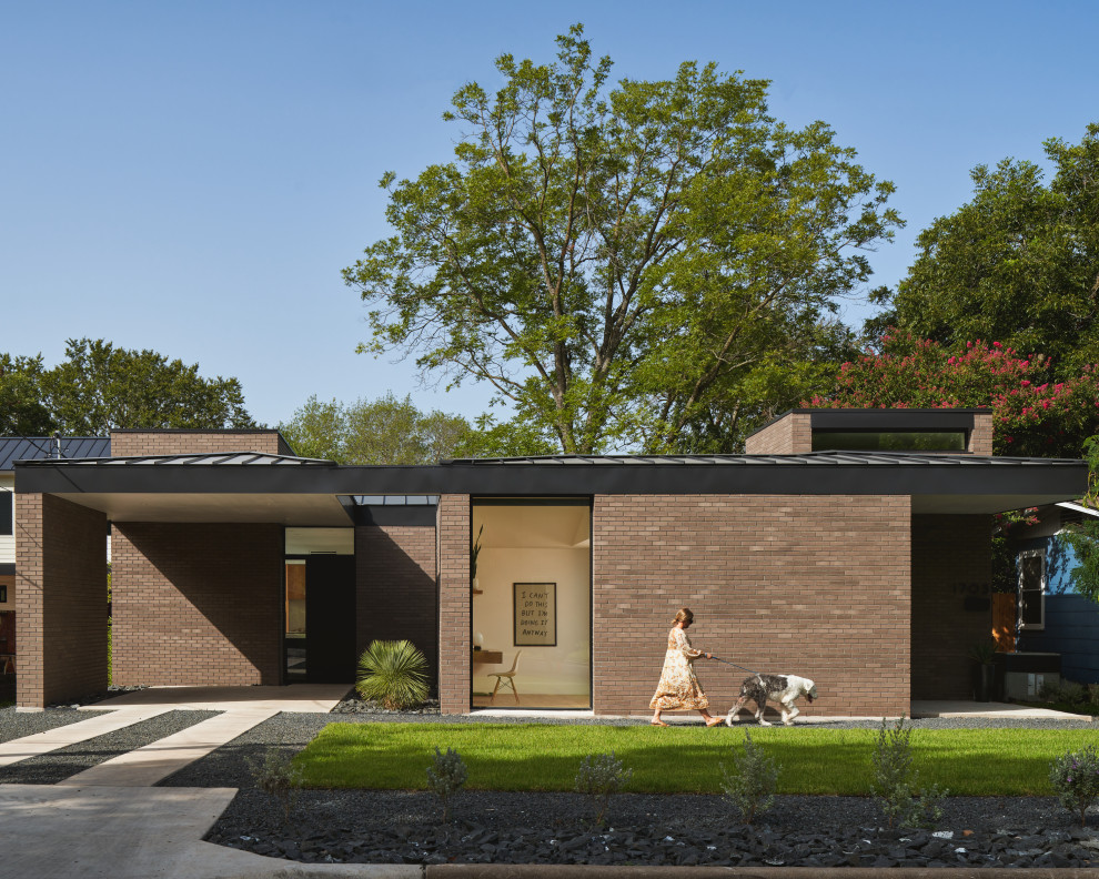 Ejemplo de fachada de casa marrón y negra moderna de una planta con revestimiento de ladrillo, tejado a cuatro aguas y tejado de metal