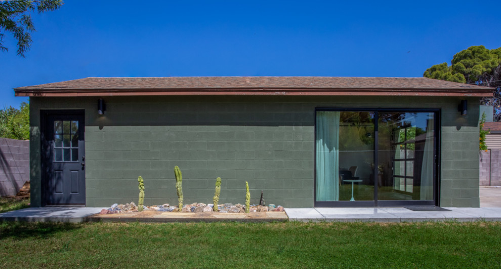 Foto della micro casa verde moderna a un piano di medie dimensioni con rivestimento in mattoni, tetto a capanna, copertura a scandole e tetto marrone