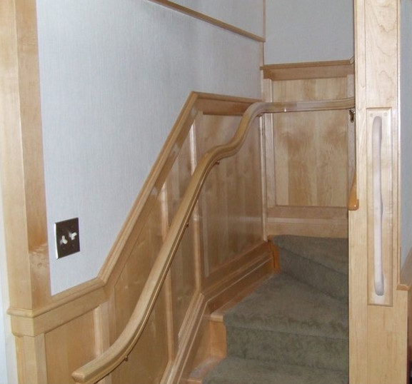 Mid-sized light wood floor staircase photo with beige walls