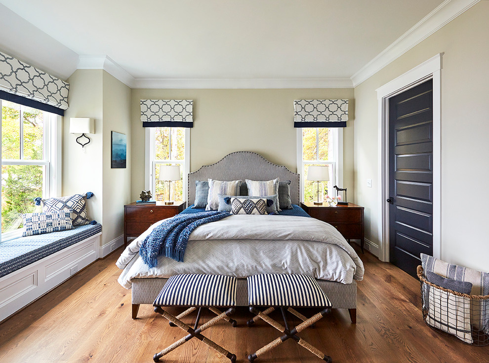 This is an example of a beach style master bedroom in Raleigh with beige walls, medium hardwood floors and no fireplace.