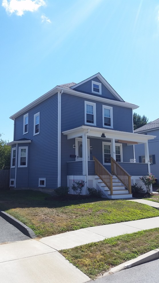 This is an example of a mid-sized traditional two-storey blue exterior in Providence with vinyl siding and a hip roof.