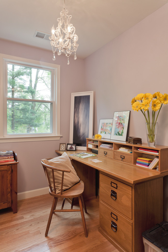 Traditional study room in DC Metro with medium hardwood floors, a freestanding desk and purple walls.