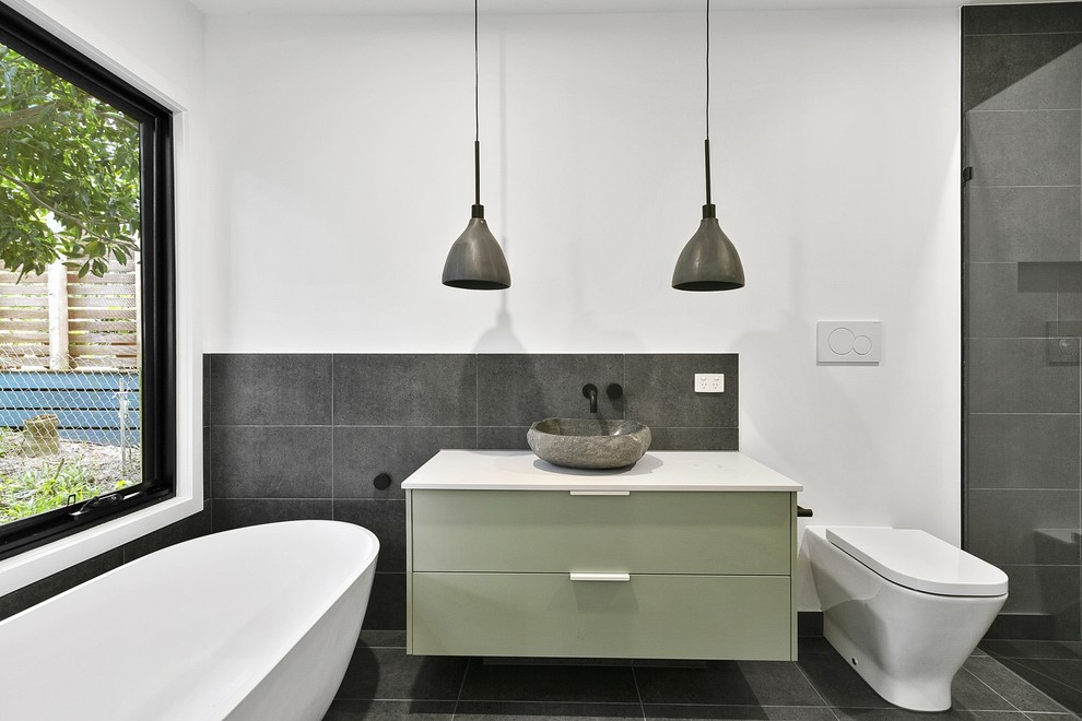 Inspiration för små moderna vitt en-suite badrum, med släta luckor, gröna skåp, ett fristående badkar, en öppen dusch, en toalettstol med separat cisternkåpa, grå kakel, vita väggar, ett fristående handfat, bänkskiva i kvarts, grått golv och med dusch som är öppen