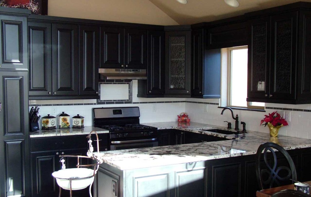 Inspiration for a mid-sized transitional u-shaped light wood floor open concept kitchen remodel in Denver with an undermount sink, beaded inset cabinets, black cabinets, marble countertops, white backsplash, subway tile backsplash, stainless steel appliances and a peninsula