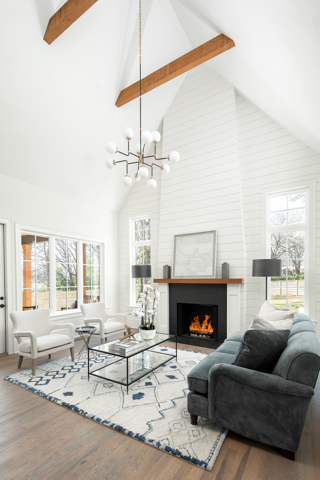 Photo of a large country open concept living room in Charlotte with a standard fireplace, a stone fireplace surround, white walls, dark hardwood floors and brown floor.