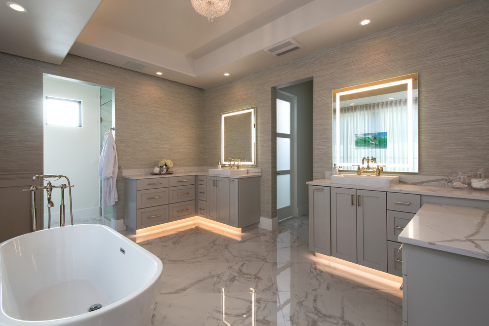 This is an example of a large contemporary master bathroom in Austin with shaker cabinets, grey cabinets, a freestanding tub, an alcove shower, a bidet, multi-coloured walls, marble floors, a drop-in sink, marble benchtops, a hinged shower door, multi-coloured benchtops and white floor.
