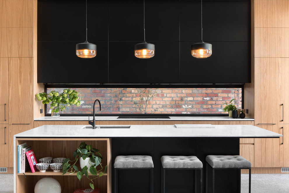 Mid-sized contemporary galley eat-in kitchen in Melbourne with an undermount sink, raised-panel cabinets, medium wood cabinets, marble benchtops, glass sheet splashback, stainless steel appliances, concrete floors and with island.