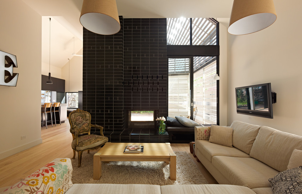 Photo of a contemporary living room in Melbourne with a two-sided fireplace and a brick fireplace surround.