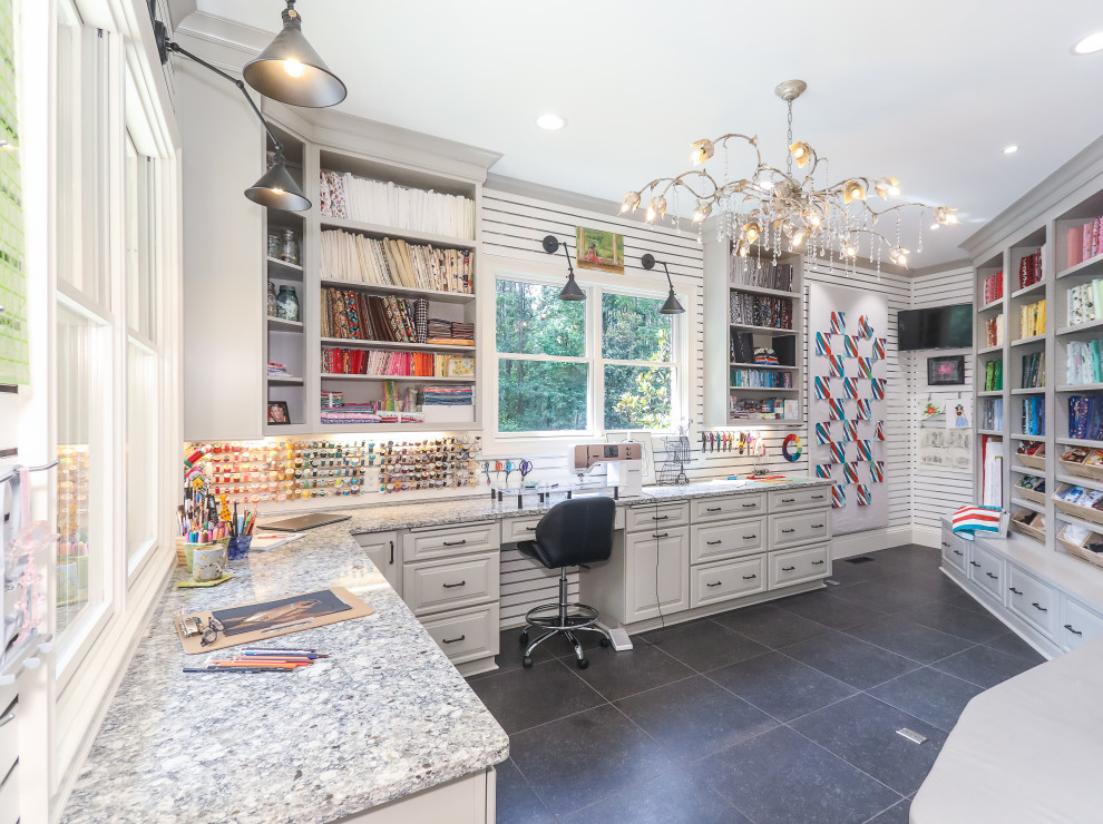 Large transitional craft room in Atlanta with white walls, porcelain floors, a built-in desk, black floor and panelled walls.