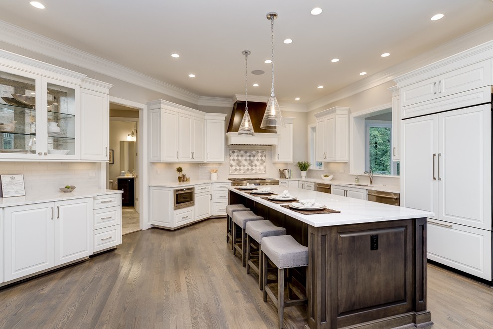 Inspiration for a large transitional u-shaped light wood floor and beige floor open concept kitchen remodel in DC Metro with an undermount sink, raised-panel cabinets, white cabinets, quartzite countertops, white backsplash, subway tile backsplash, stainless steel appliances and an island