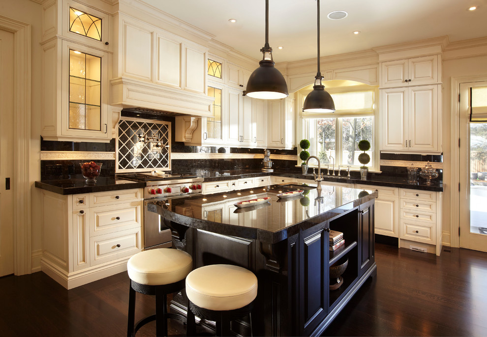 Design ideas for a large traditional u-shaped open plan kitchen in Toronto with raised-panel cabinets, stainless steel appliances, an undermount sink, white cabinets, granite benchtops, multi-coloured splashback, dark hardwood floors, with island and black benchtop.