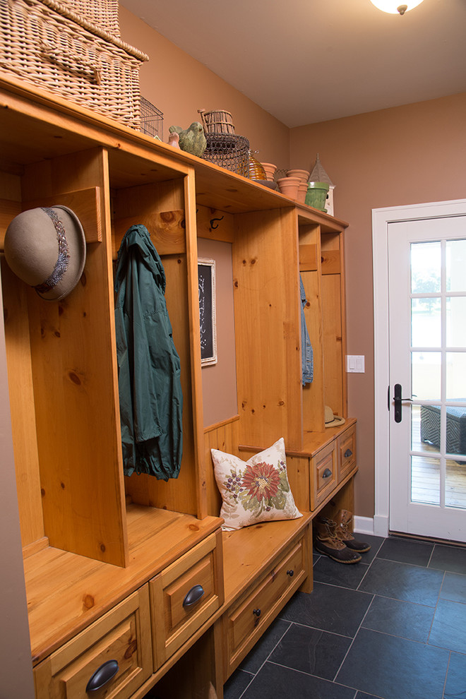 Example of a mountain style slate floor mudroom design in Chicago with beige walls