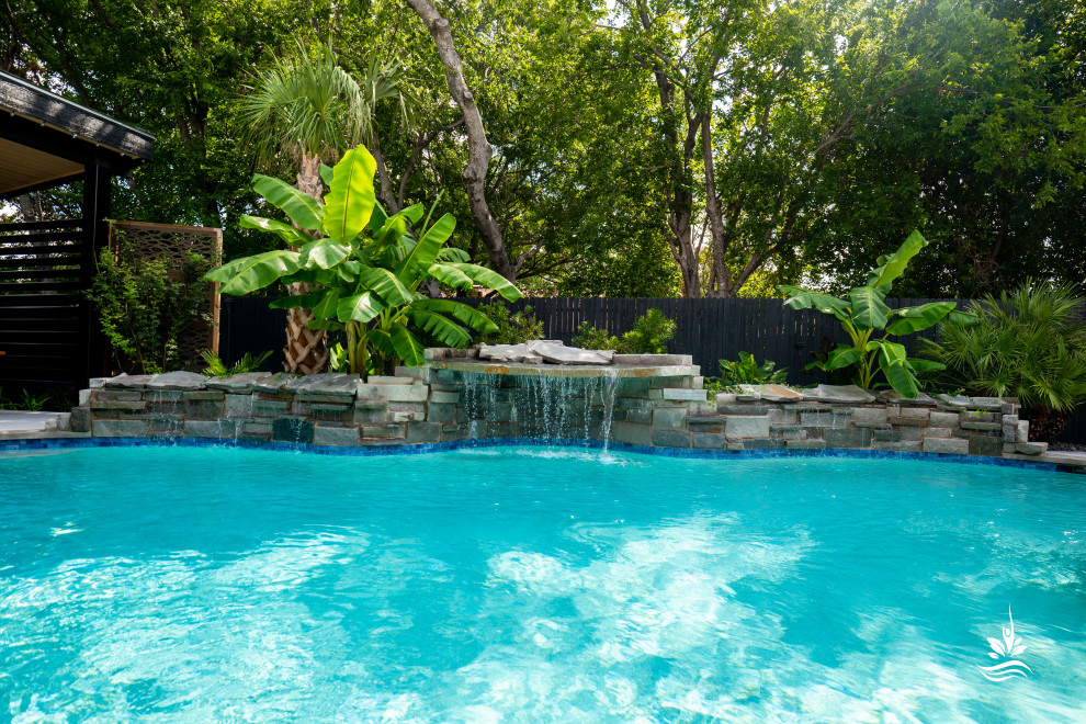 Ispirazione per un'ampia piscina naturale etnica personalizzata dietro casa con pavimentazioni in pietra naturale