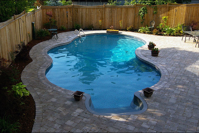 Mid-sized transitional backyard custom-shaped and concrete paver lap pool photo in Toronto