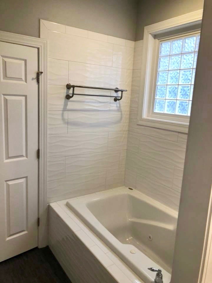 Inspiration for a master yellow tile and porcelain tile porcelain tile and gray floor bathroom remodel with raised-panel cabinets, white cabinets, a hot tub, gray walls, an undermount sink, quartz countertops, a hinged shower door and white countertops