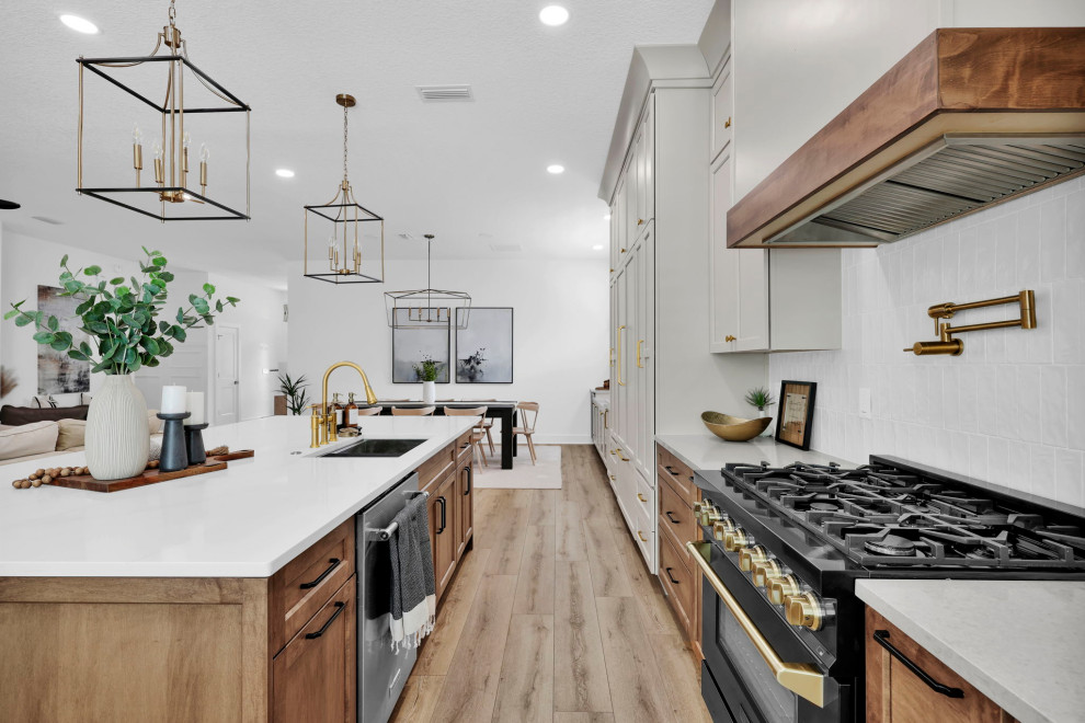 Inspiration for a large beach style open plan kitchen in Jacksonville with shaker cabinets, quartz benchtops, white splashback, panelled appliances, with island and white benchtop.