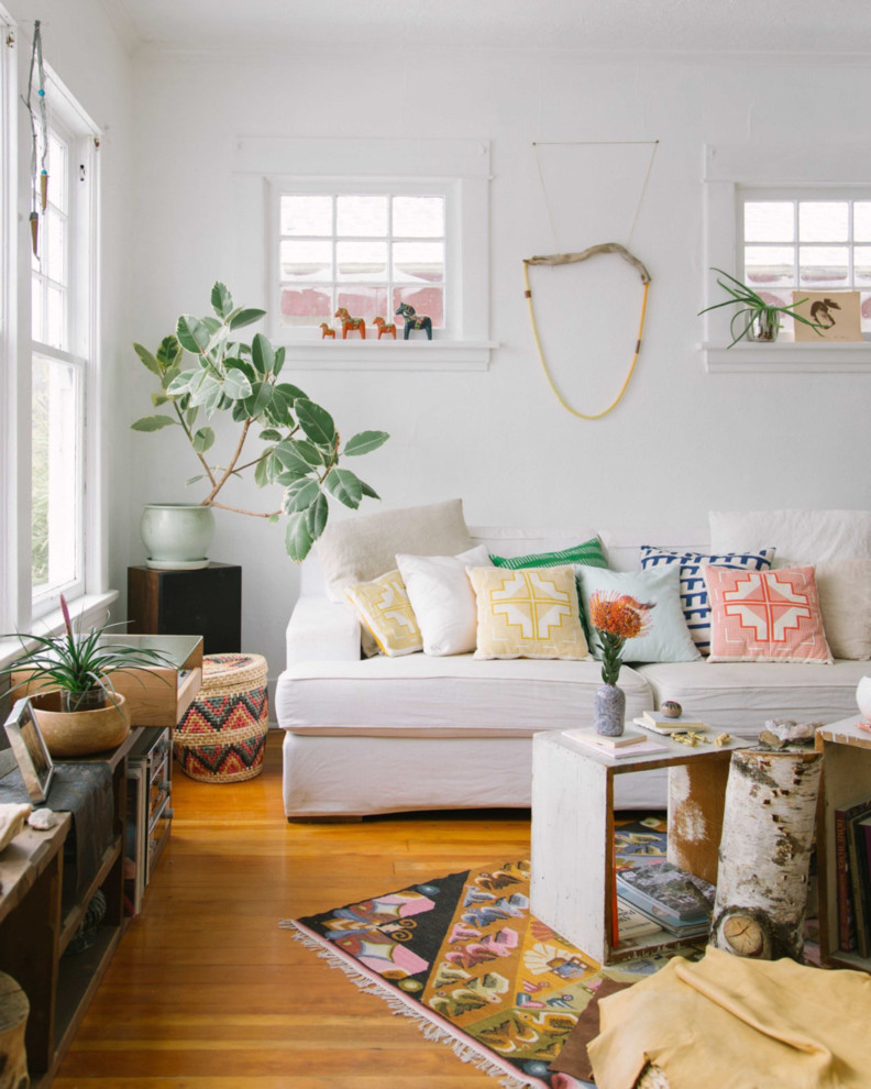 This is an example of an eclectic living room in Portland with white walls and medium hardwood floors.