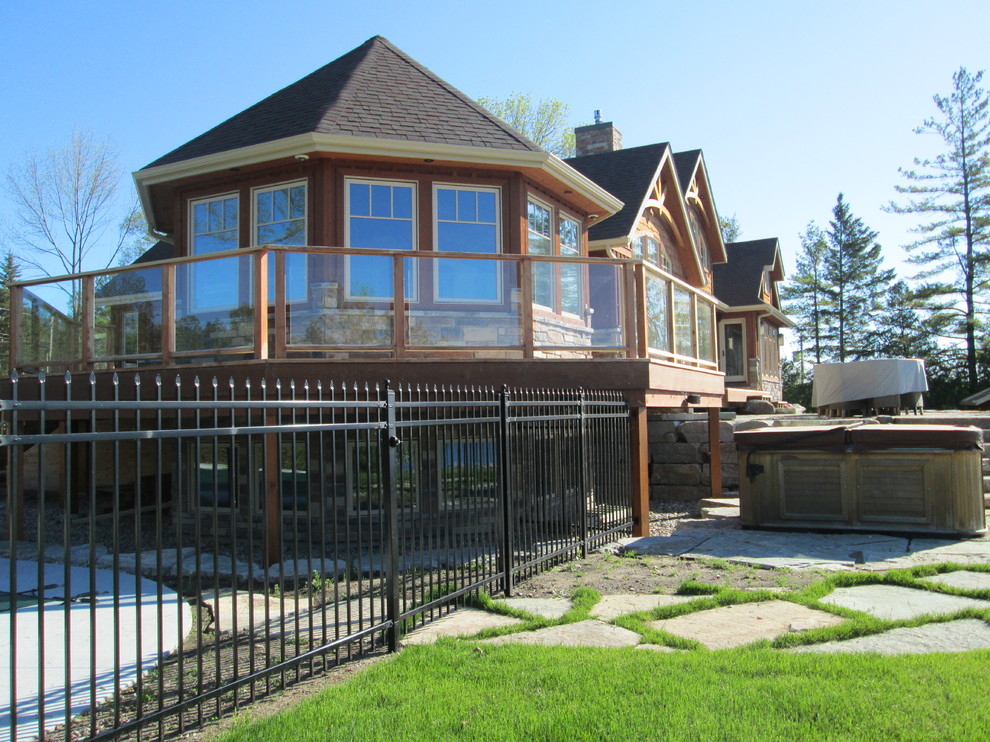 Large country two-storey brown exterior in Toronto with stone veneer and a gable roof.