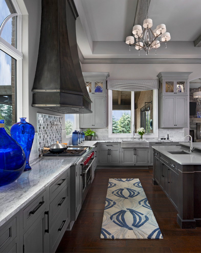 Kitchen - transitional dark wood floor kitchen idea in Detroit with a farmhouse sink, recessed-panel cabinets, gray cabinets, gray backsplash, stainless steel appliances and an island