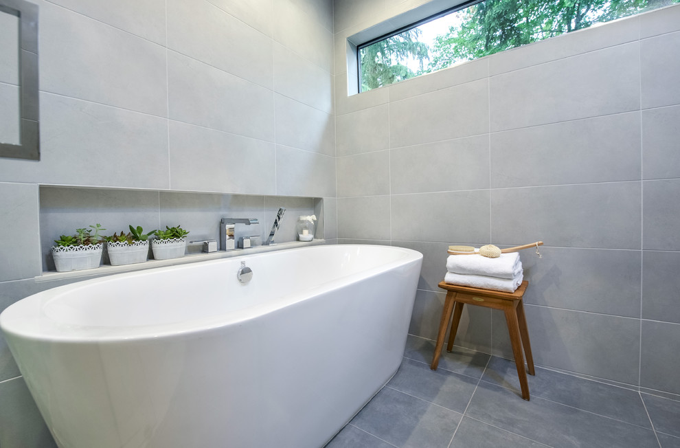 Inspiration for a mid-sized transitional master gray tile and porcelain tile porcelain tile freestanding bathtub remodel in Seattle with shaker cabinets, gray cabinets, a two-piece toilet, white walls, an undermount sink and quartzite countertops