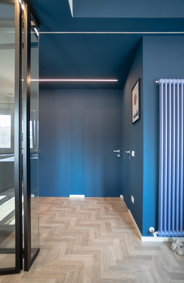 Esempio di un ingresso contemporaneo di medie dimensioni con pareti blu, parquet chiaro, pavimento grigio e armadio
